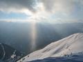 Abertausende Schneekristalle - vom leichten Wind aufgewirbelt - glnzen in einem Sonnenstrahl, der sich seinen Weg durch die immer dnner werdenden Wolken bahnt.