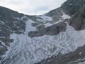 Abstieg ber den ziemlich ausgeaperten Edelgriegletscher - eher ein Dauerfirnfeld. Steigeisen waren heute keine erforderlich. Rechts oberhalb der Schnee-Engstelle auf der linken Bildseite gehen 2 Wanderer steil bergauf ...