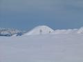 Bei den eingeschneiten Wegweisertafeln auf der Akarscharte - im Hintergrund die Kuppe des Meregg