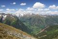 Endlich am Bergkamm. Tiefblick auf der anderen Seite zur Straengabelung beim Kesslerkreuz. Nach links oben zieht die Mautstrae zur Breitlahnalm hinein. Im Hintergrund die alles berragende Hochwildstelle.