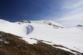 Die aperen Stellen mit feuchtem Gras sind immer nur so kurz, dass es sich nicht lohnt, die Schneeschuhe abzuschnallen. Oben am Hochwart-Gipfel erkennt man links und rechts weitere Gipfelaspiranten.
