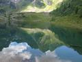 an dessen Ufer sich einige Wanderer entspannen.
