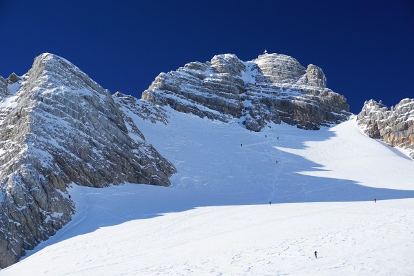 Bevor es losgeht beobachten wir noch einmal fasziniert die Dachstein-Gipfelstürmer am Weg zum weiß leuchtenden Gipfelkreuz.