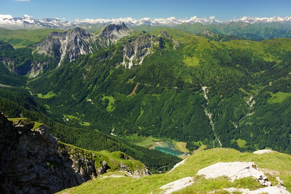 Tiefblick vom Grat zum Jägersee - im Hintergrund die schneebedeckten Gipfel der Hohen Tauern um den Großglockner