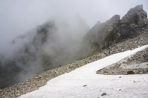 Martin unterhalb des Schneefeldes auf einem Steinwall stehend.