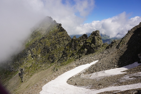 Das Ende des Schneefeld-Bogens zeigt hinauf auf das Gedenkkreuz.