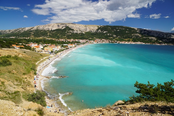 Der beliebte Kieselstrand von Baska. Links dahinter die Mondlandschaft Hlam