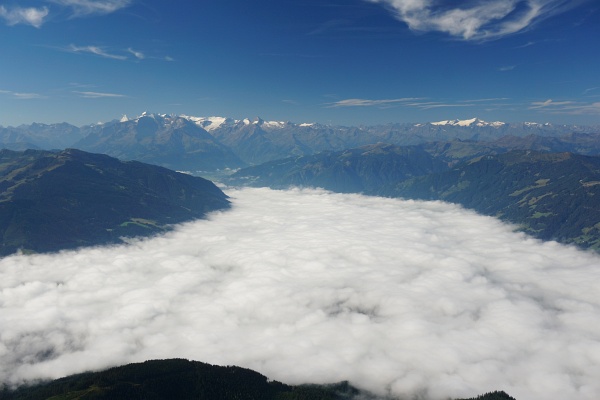 Am frühen Morgen war Saalfelden noch unter der Nebeldecke verborgen. Im Hintergrund die gletscherbedeckten Dreitausender der Hohen Tauern.