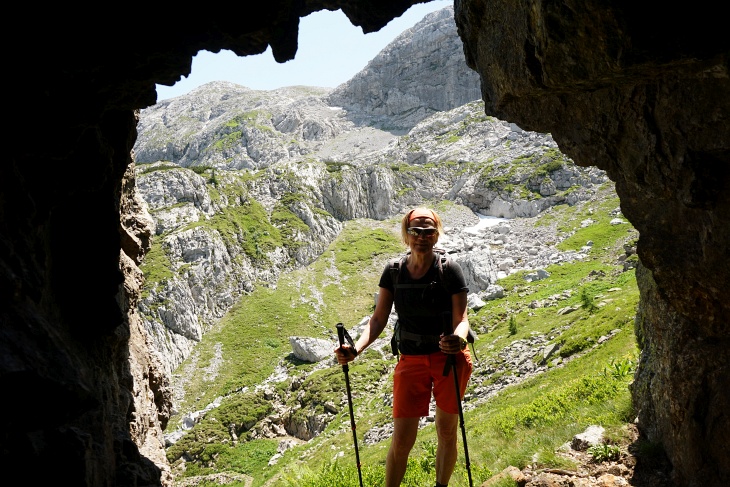 Diese wohl händisch in den Fels geschlagene Höhle könnte ein Kriegsrelikt sein. Im Hintergrund (links) das Abstiegsgelände vom Roßkofel.