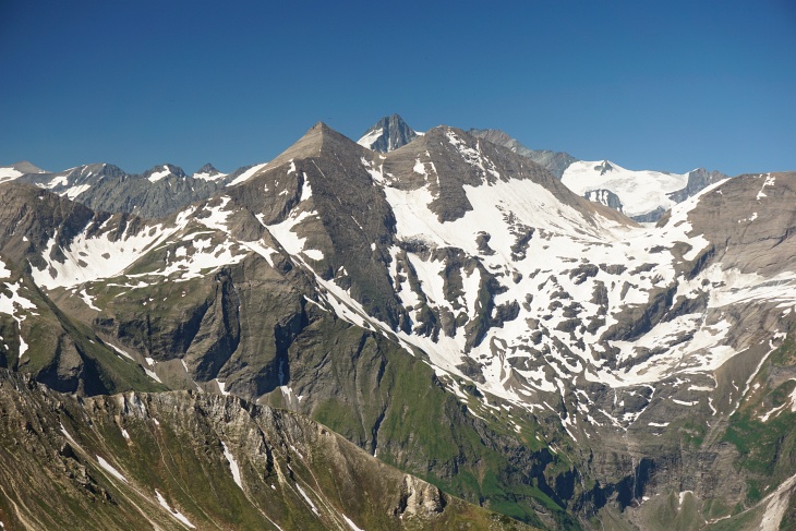 Immer wieder erhascht man auf dieser Route einen Blick auf ein "Spitzerl" des im Hintergrund liegenden Großglockners. Links davor die auffallend formschöne Pyramide des Sinwellecks.