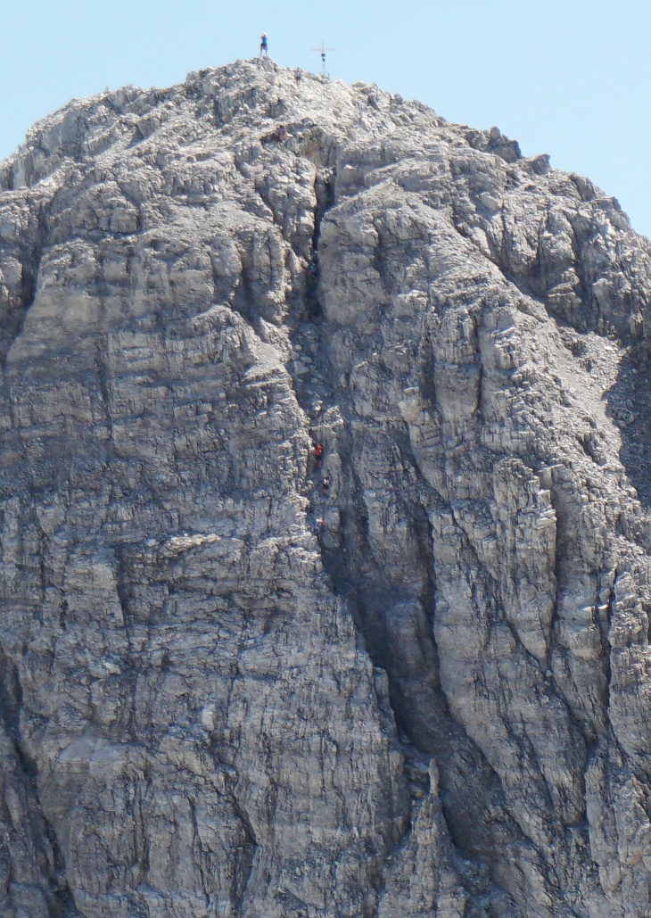 Wenn wir schon bei Zoomblicken sind: Im Kamin kamen gerade 5 weitere Bergsteiger herunter. 3 in Bildmitte und 2 weiter oben im Bereich der dunklen Engstelle.