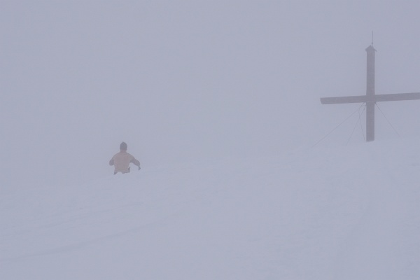 Beim Gipfelkreuz am Pleschnitzzinken. Harte Burschen ziehen sich auch im peitschenden Wind um.